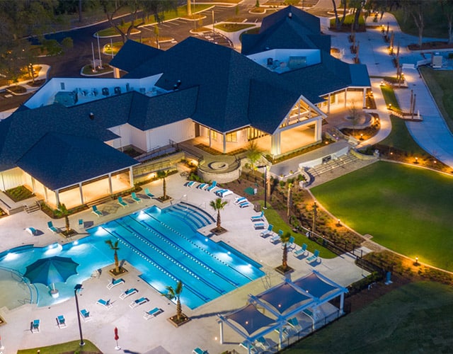 Aerial view of the Marshwood Clubhouse with resort-style outdoor pool, cabanas and luxurious landscaping.