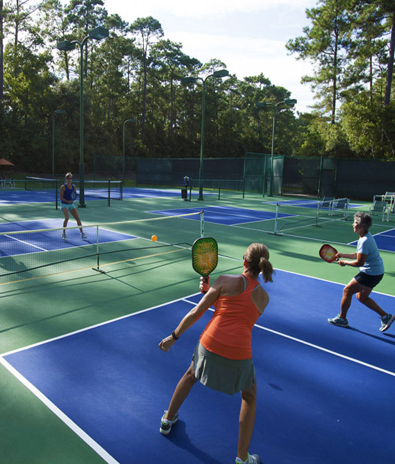 Several teams playing a lively round of pickleball on one of the 14 available courts at The Landings.
