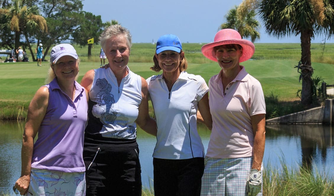 Four female golfers gather for a photo on the golf course during the Together for a Cure outting.
