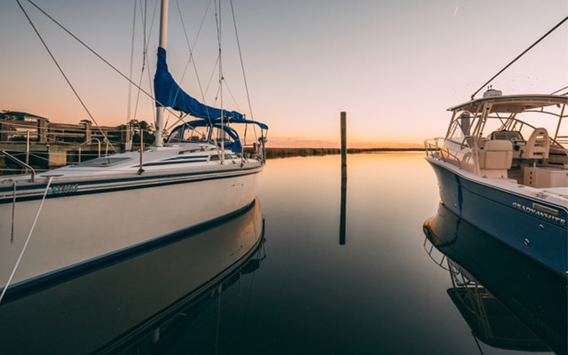 A sunrise view of the Intracoastal waterway between two boats docked at the Delegal Creek Marina.