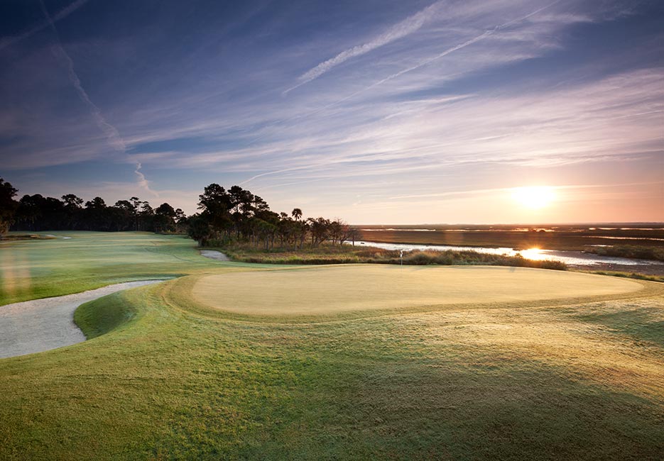 A green on the Palmetto golf course hosts the morning due as the sun begins to rise on this course designed by Arthur Hills.