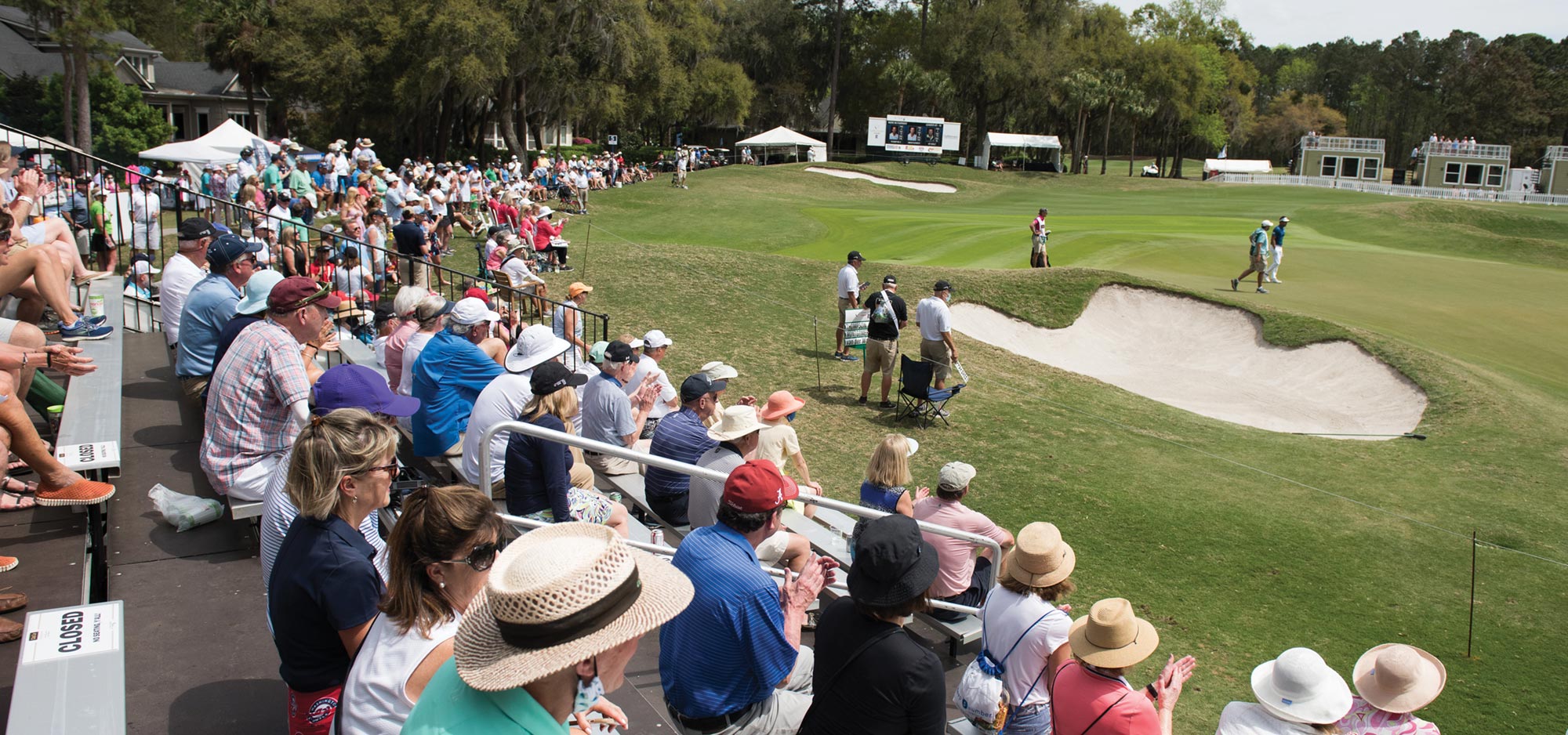 Golf fans fill the gallery as golfers play in a tournament on one of the six championship golf courses.