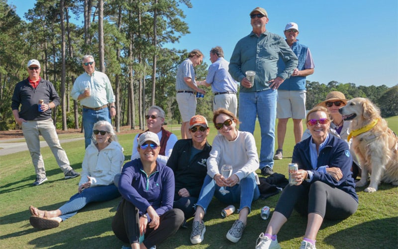 Neighbors gather on a community golf course to enjoy a sunny Savannah day.