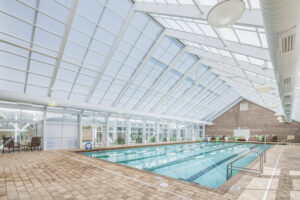 A lap pool under a glass vaulted ceiling at Oakridge fitness center.