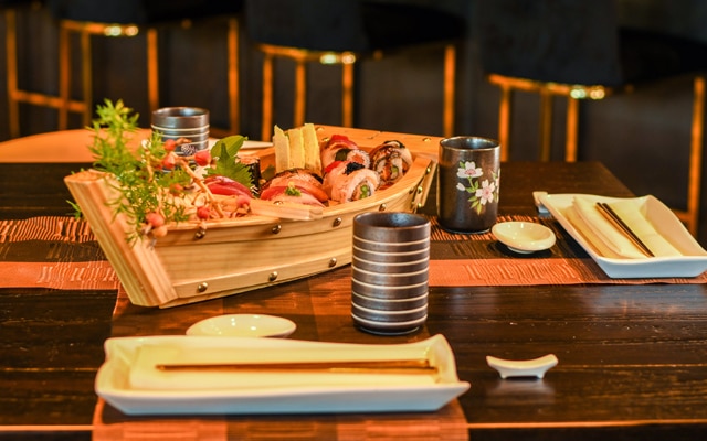 A boat of sushi and some chopsticks don the table at FinJin at Palmetto, The Landings' upscale sushi and noodle bar.