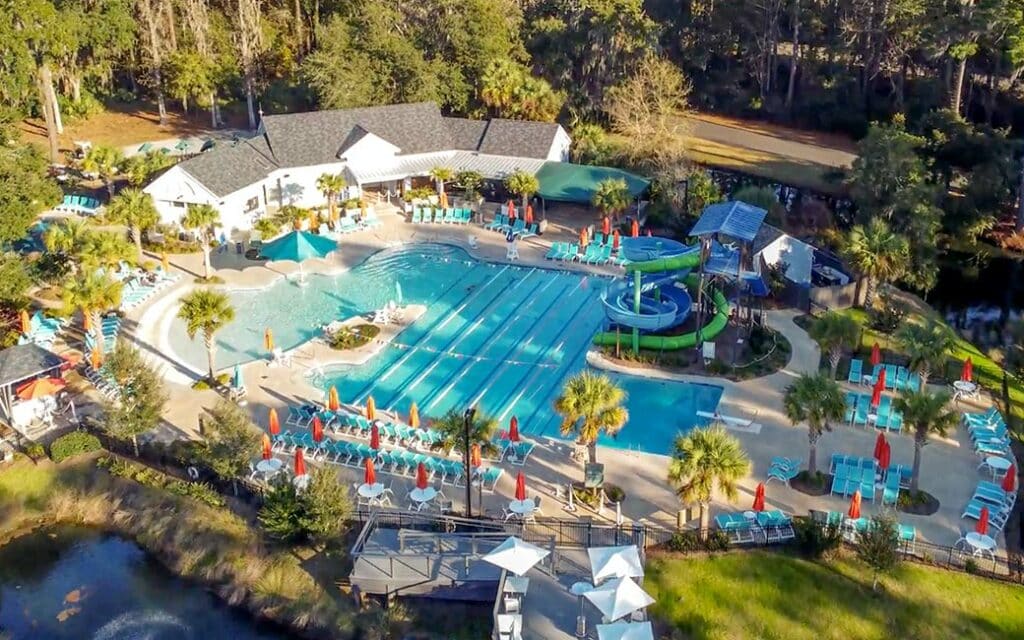 A birds eye view of  Franklin Creek pool that has a zero-entry shallow end, two slides, a diving board, and a pirate-themed children's splash pad, complete with pirate ship water feature.