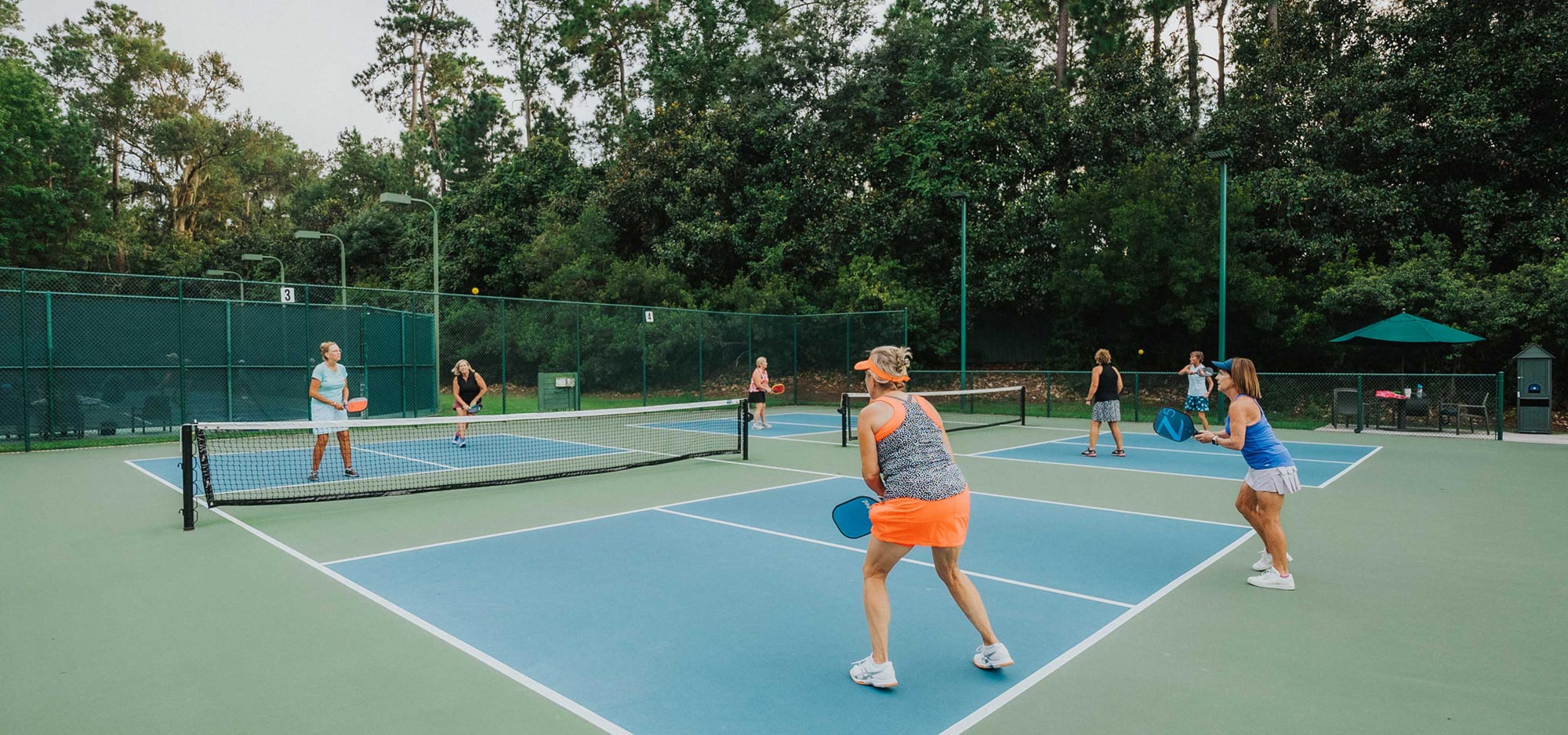 A group of women play on two of the 14 pickleball courts available as part of the Court Sports in the Athletic Club at The Landings.