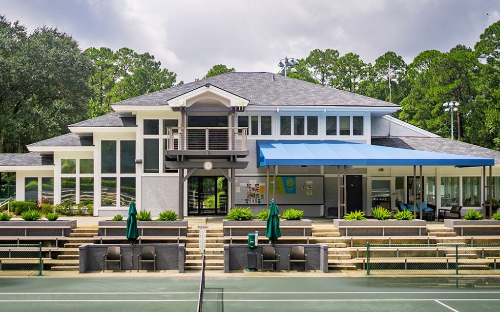 The Landings Golf and Athletic Club is a large white building with a blue canopy that houses the Tennis Academy.